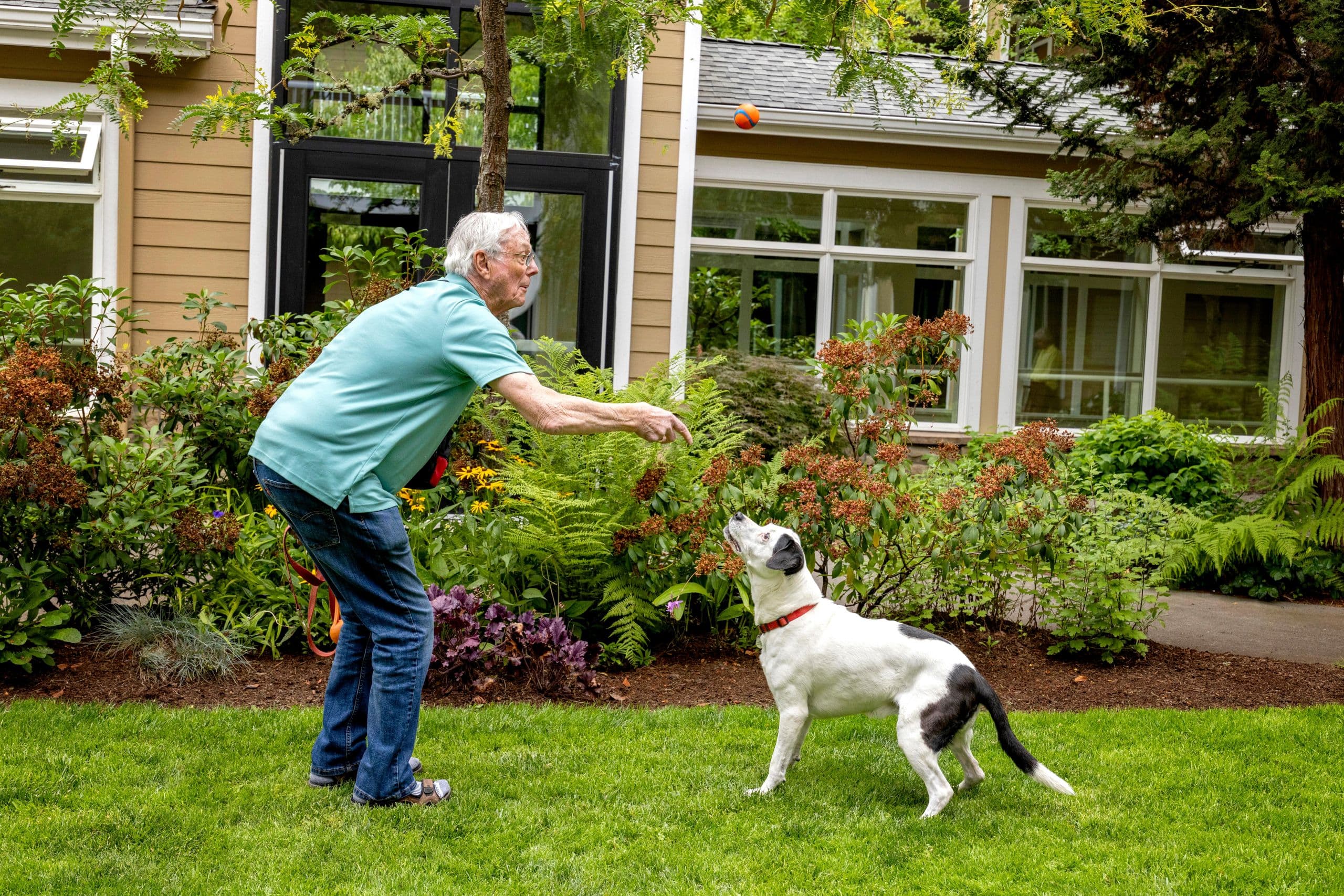 A resident playing fetch with his dog at Cascade Manor