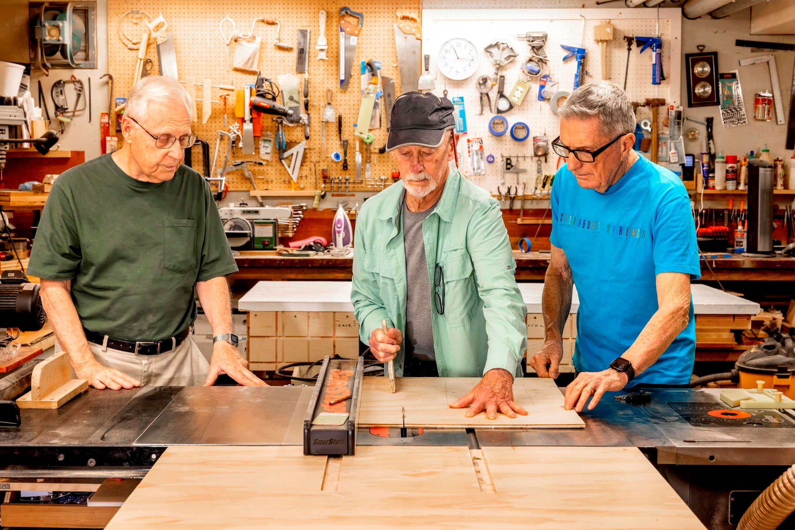 Group of three men in woodworking shop