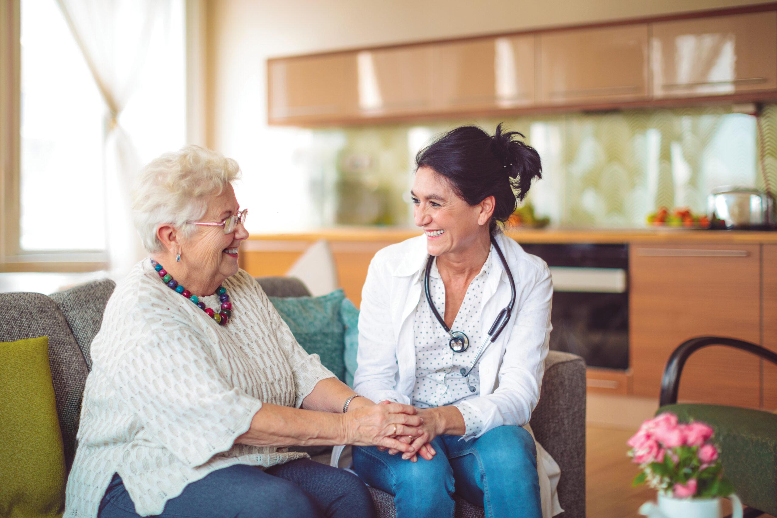 A nurse visits and cares for an older woman at home.