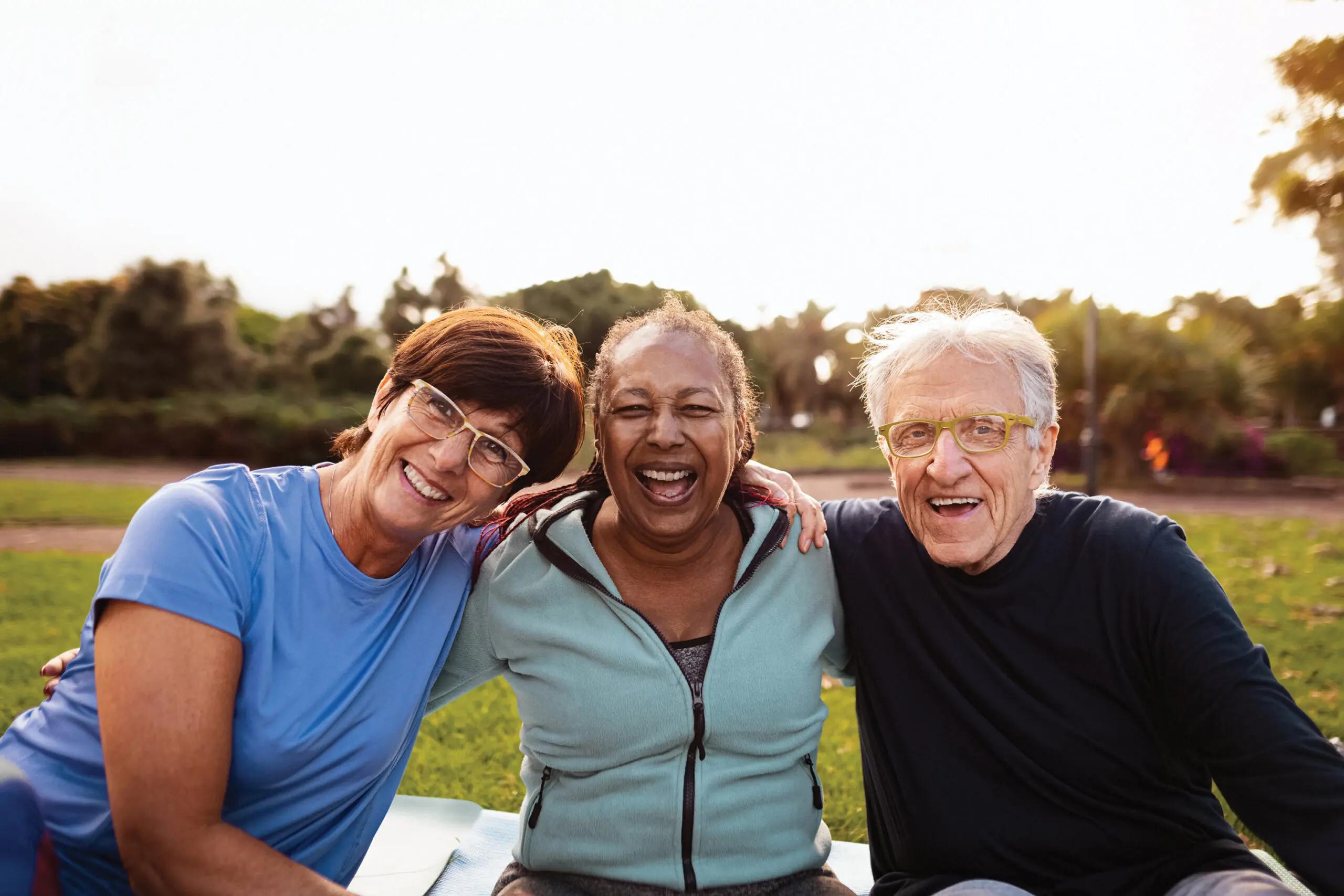 Three active friends smile outdoors